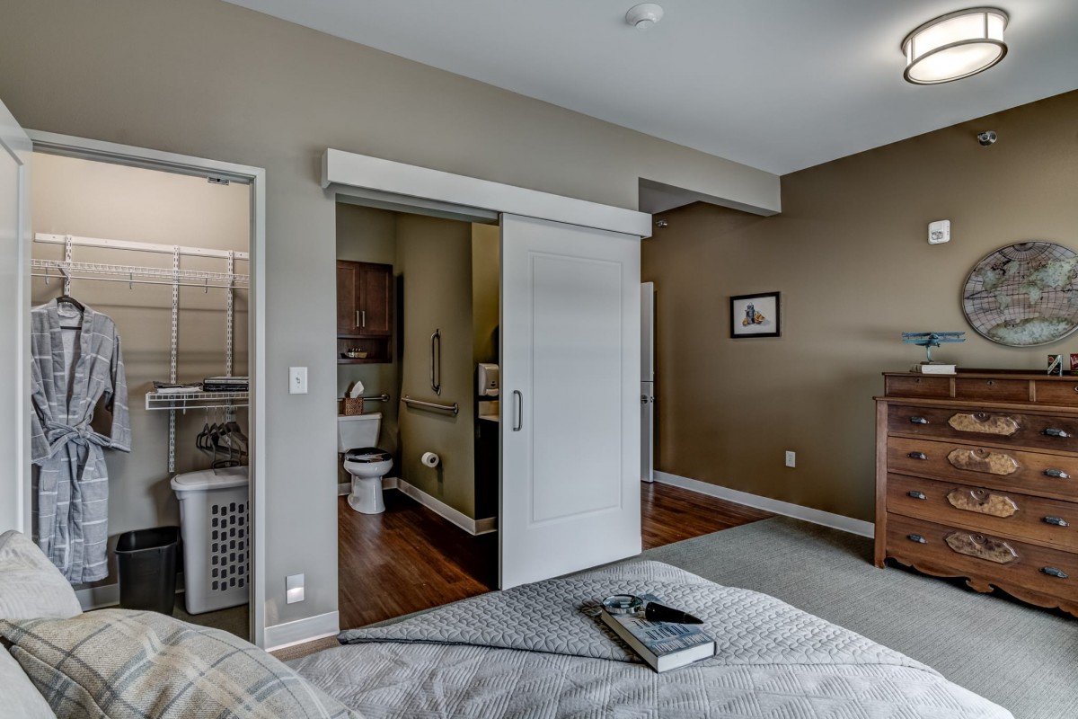 A cozy bedroom with a modern sliding door leading to the bathroom.