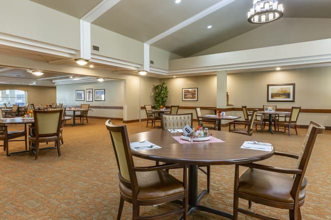 A spacious dining room with neatly arranged tables and chairs.
