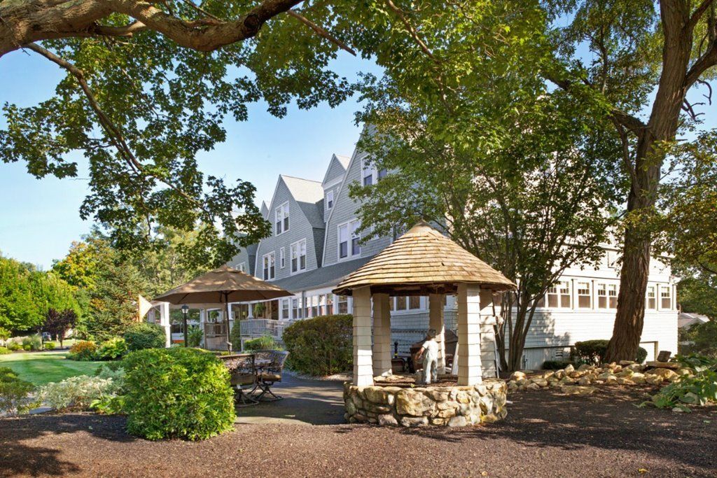 A charming building with a gazebo surrounded by lush greenery.