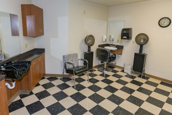 Interior of a hair salon with checkered flooring and hair styling stations.