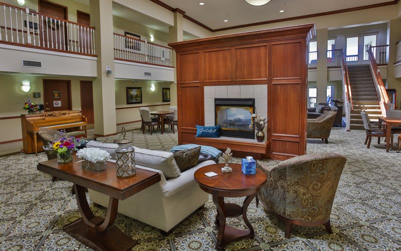 A cozy lobby with comfortable seating and a central fireplace.