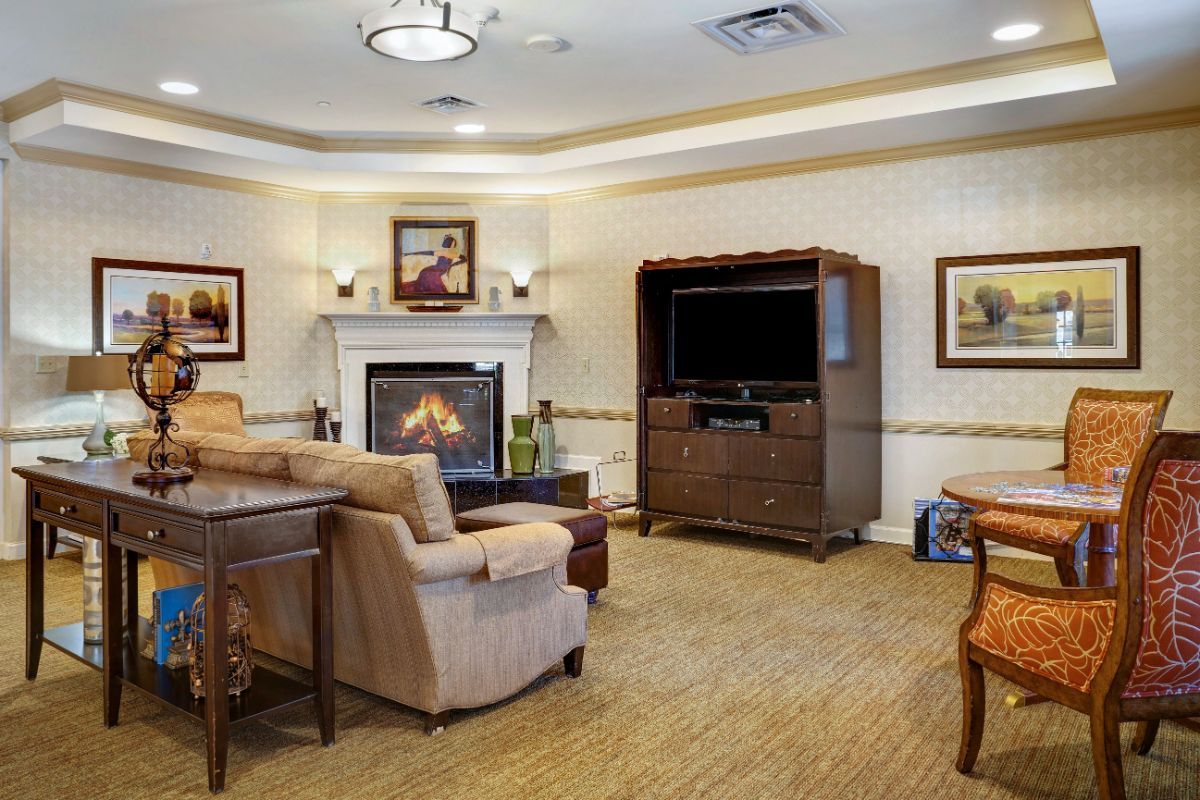A cozy living room featuring a fireplace, comfortable seating, and a television.