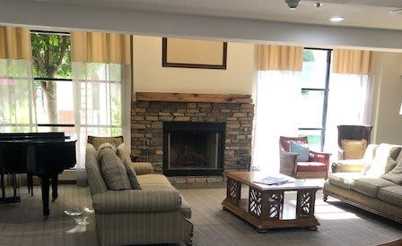A cozy living room with a stone fireplace, comfortable sofa, and a wooden coffee table.