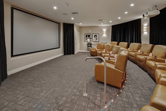 A modern home theater with comfortable seating and a large projection screen.