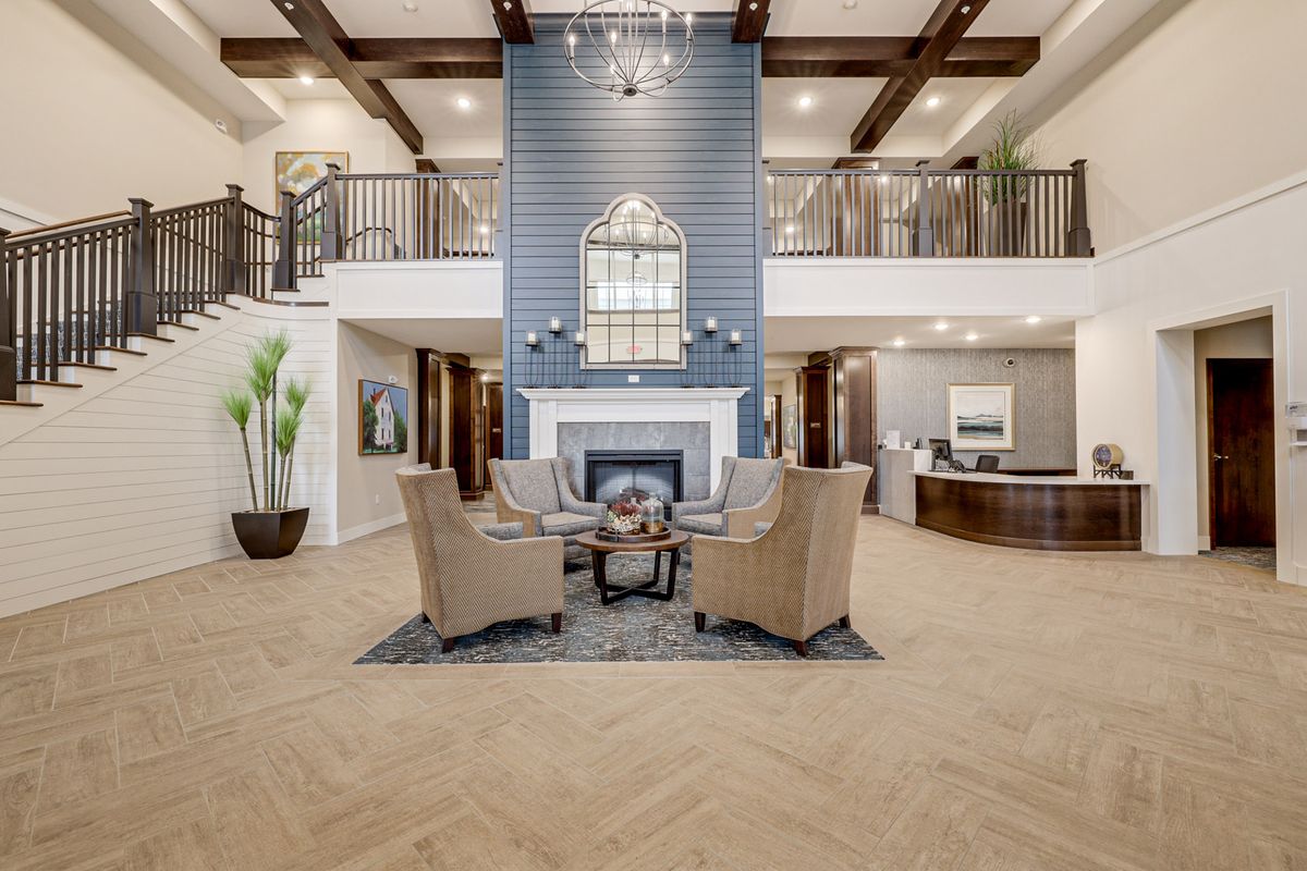 A modern lobby with a central fireplace and comfortable seating area.