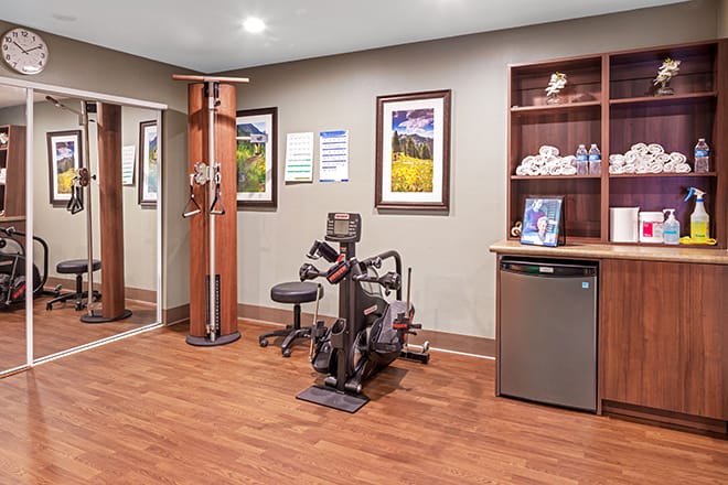A small fitness room equipped with exercise machines and amenities.