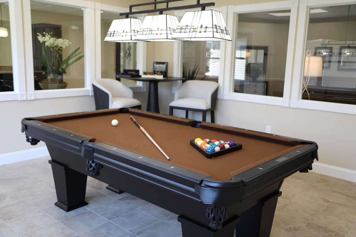 A modern game room featuring a pool table and comfortable seating.