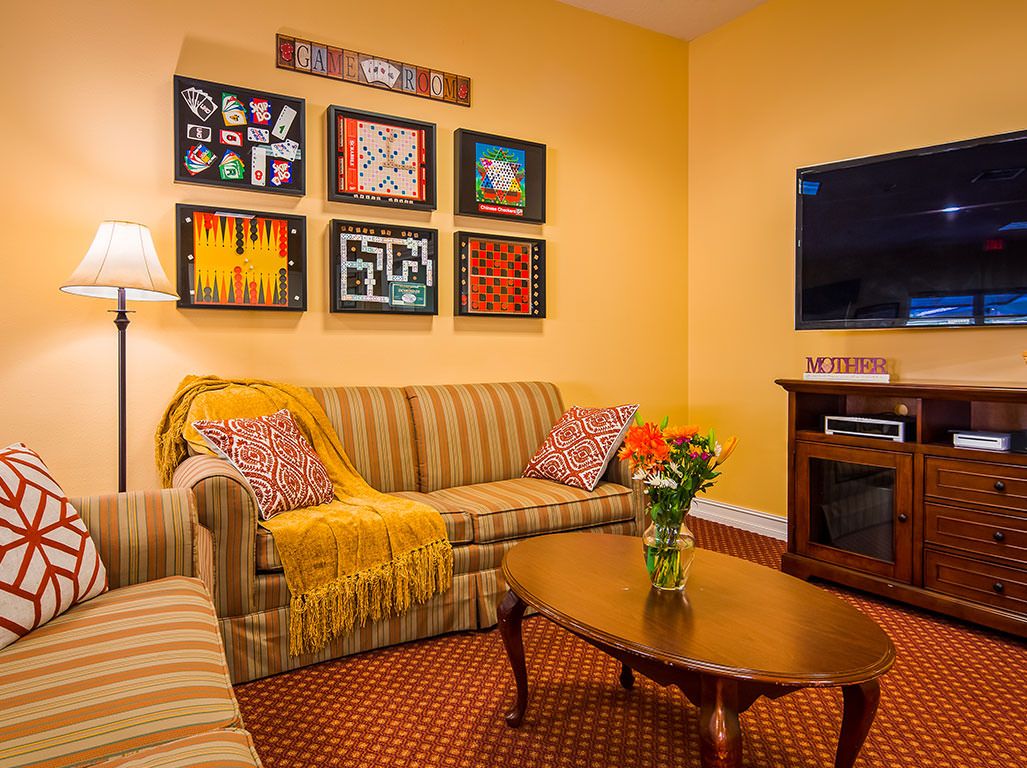 A cozy living room with a striped sofa, wooden coffee table, and colorful artwork on the wall.