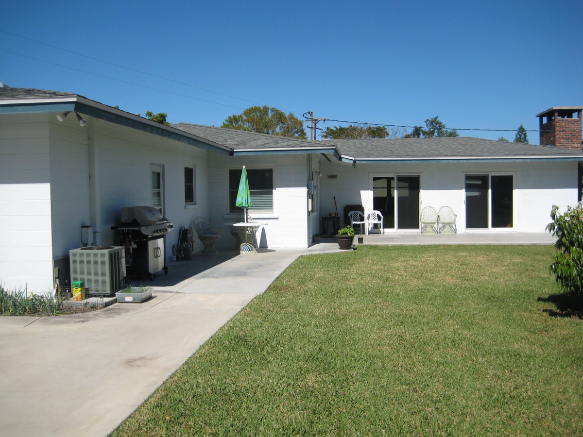 A residential backyard with a lawn and patio area.