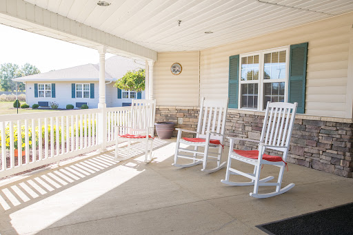 A cozy porch featuring white rocking chairs, perfect for enjoying a sunny day.