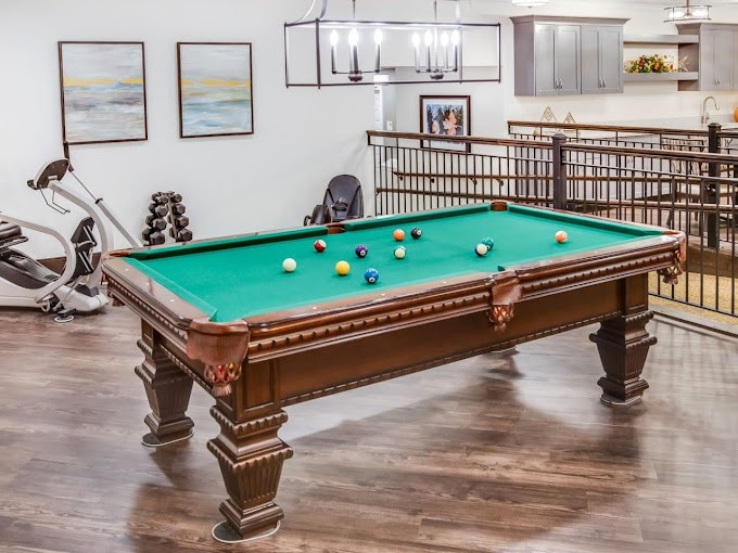 A luxurious game room featuring a classic billiards table with green felt.