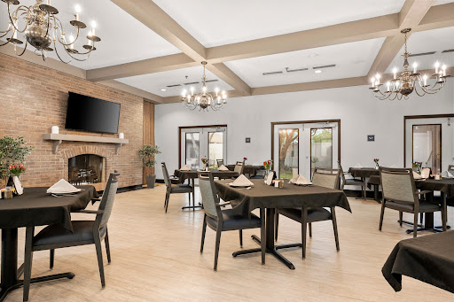 A stylish and modern dining area with elegant wooden furniture and contemporary chandeliers.