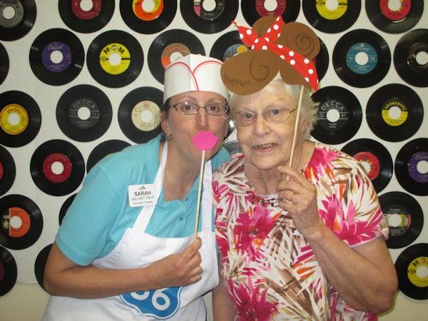 Two people having fun with costumes and props at a themed party.