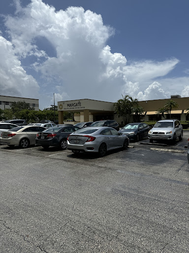 A busy parking lot at a shopping center under a cloudy sky.