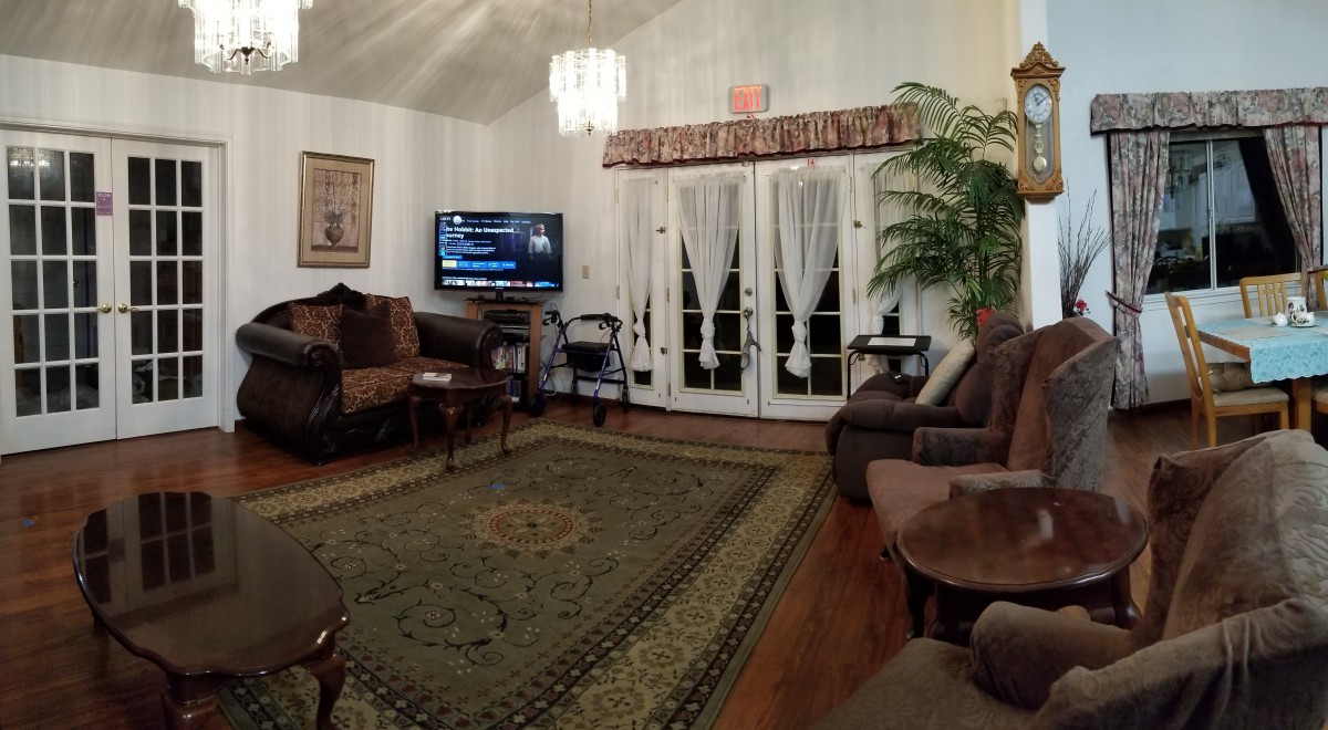 A cozy living room with elegant furniture, a large television, and tasteful decor.