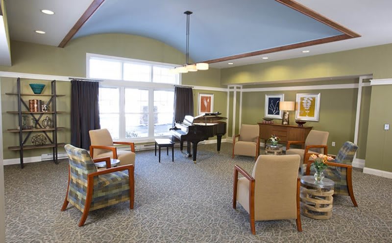 A cozy lounge area with a piano and comfortable seating.