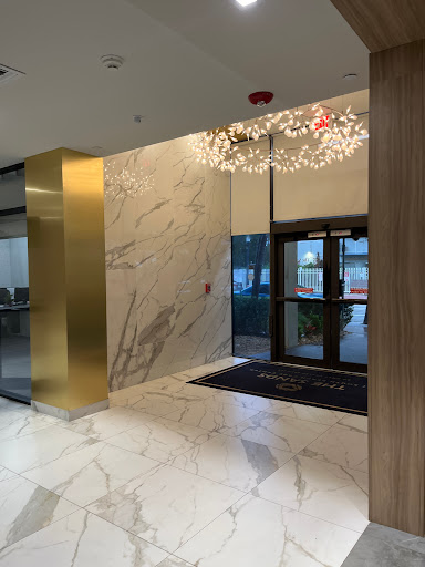A stylish modern lobby featuring marble walls, contemporary lighting, and a welcoming entrance.