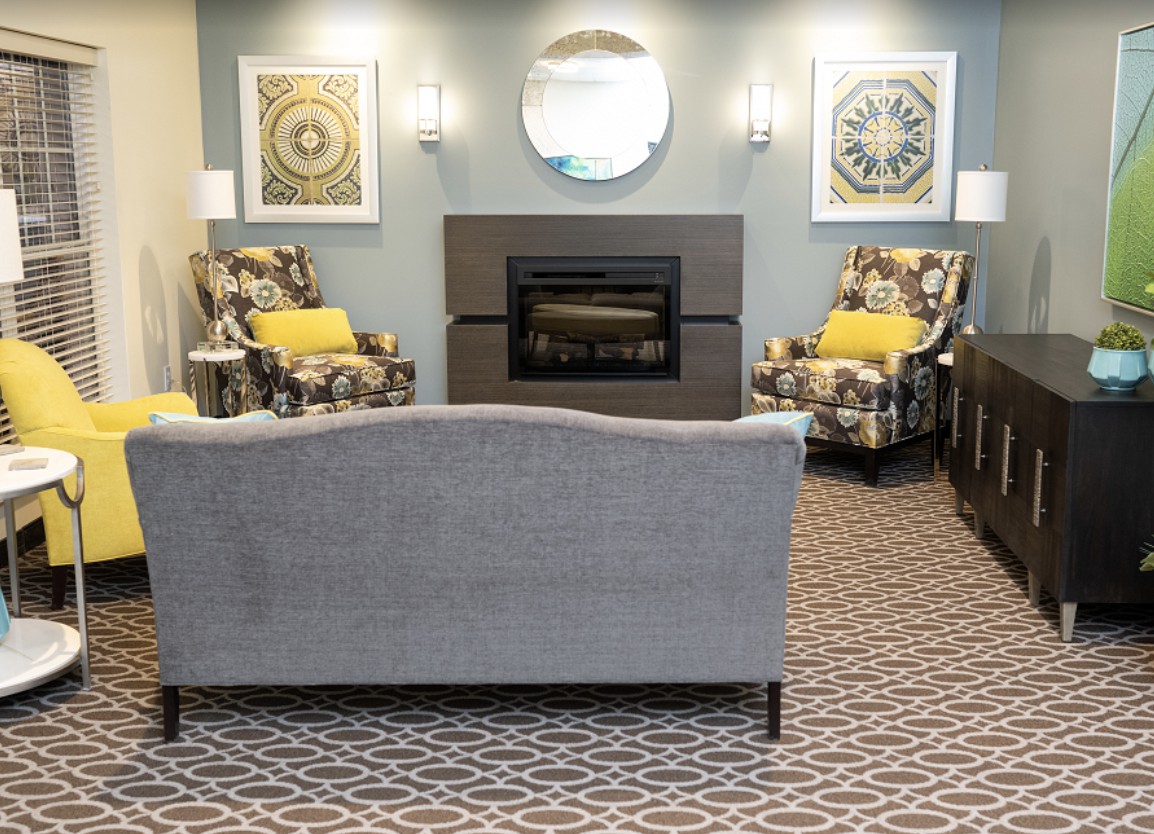 A cozy living room featuring a central fireplace, comfortable seating, and stylish decor.