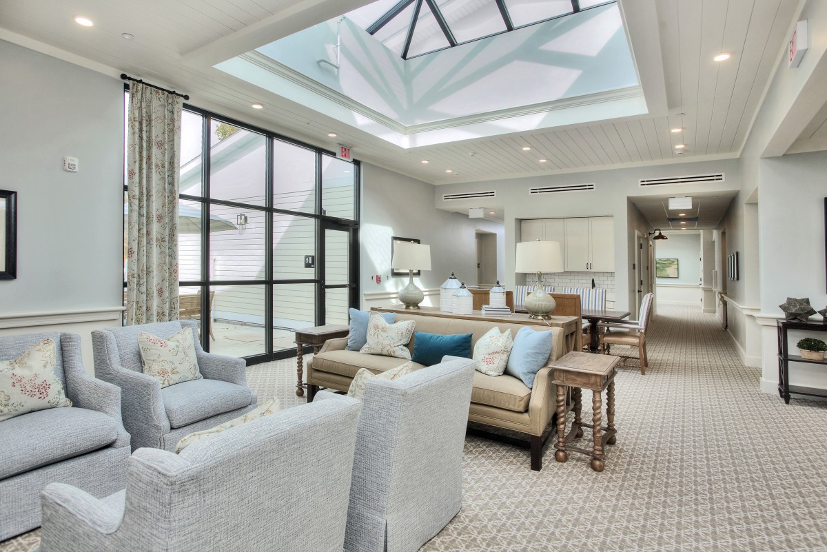 A modern living room with a skylight, featuring stylish furniture and bright, spacious interior design.