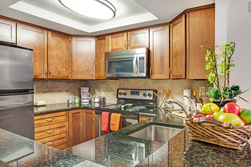 A modern kitchen with wooden cabinets and stainless steel appliances.