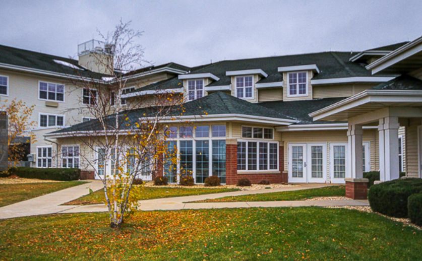 A large modern house with multiple windows and a well-maintained lawn.