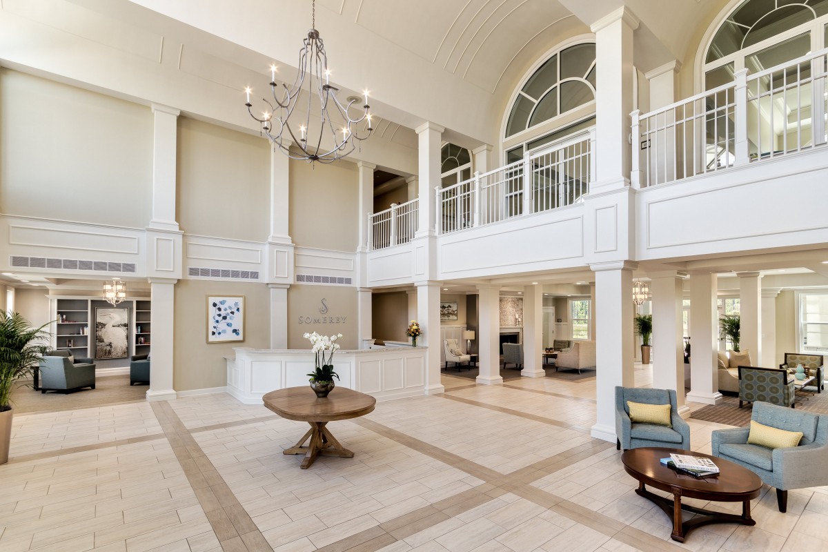 Spacious lobby with elegant chandelier and stylish decor.