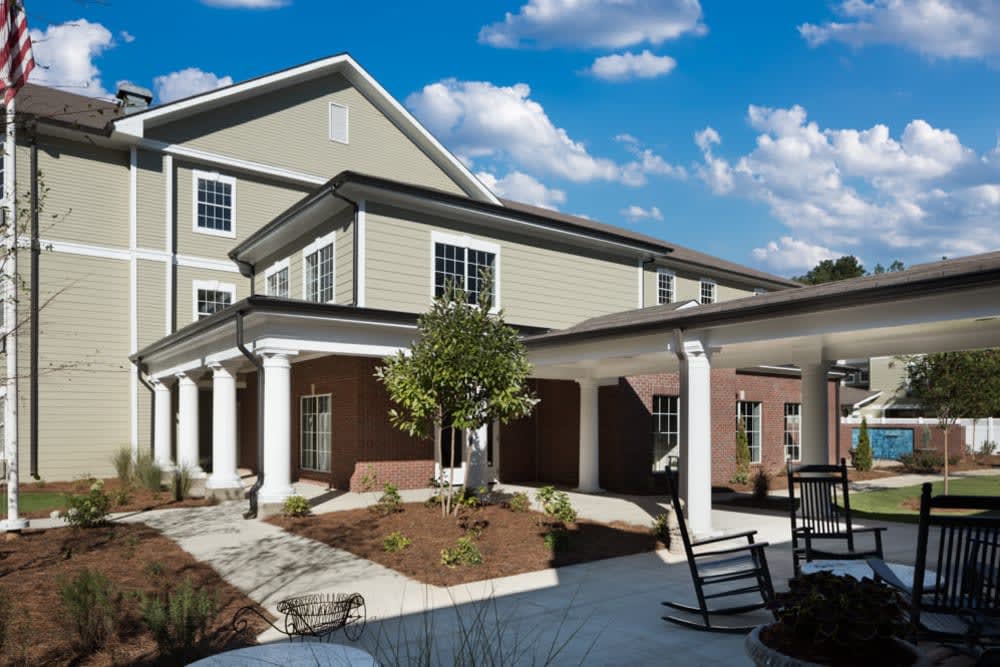 A modern residential building with a landscaped courtyard and outdoor seating area.