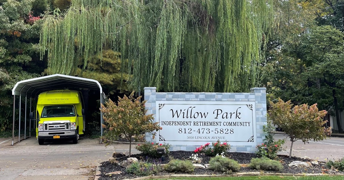 Entrance sign to Willow Park surrounded by greenery and landscaping.
