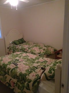 A cozy bedroom featuring two twin beds with floral bedding.