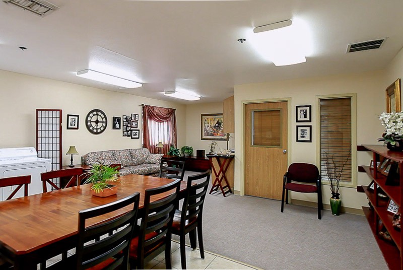A well-lit meeting room with a large conference table and chairs, featuring cozy decor.