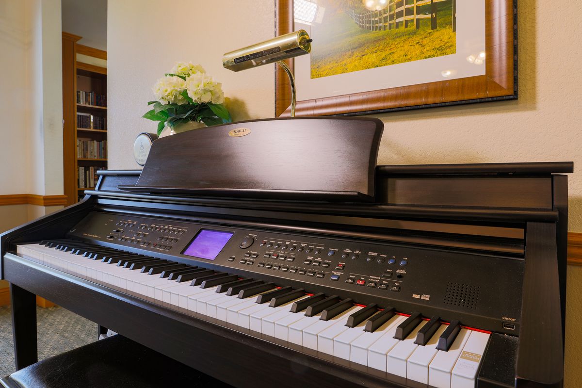 A digital piano in a room adorned with flowers and artwork.