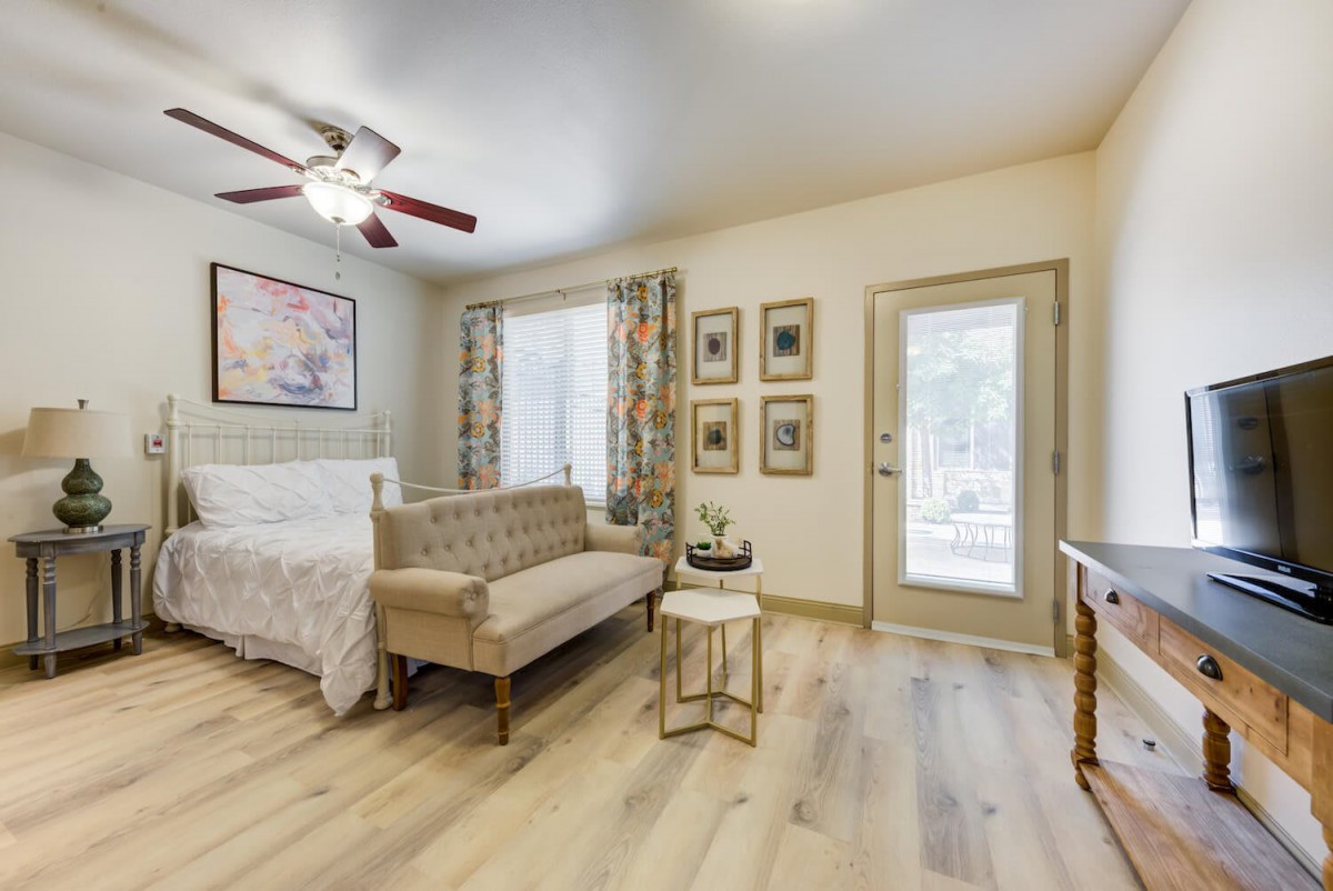 A cozy bedroom with stylish decor, including a comfortable sofa and wooden flooring.