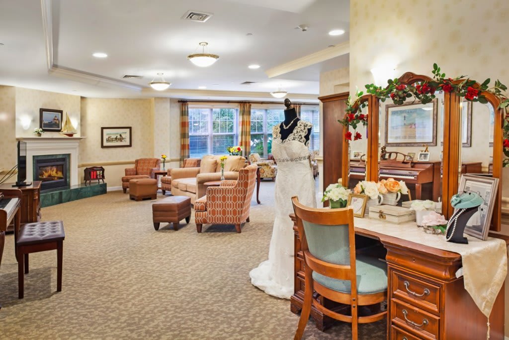A cozy living room featuring a mannequin dressed in a wedding gown, surrounded by comfortable seating and elegant decor.