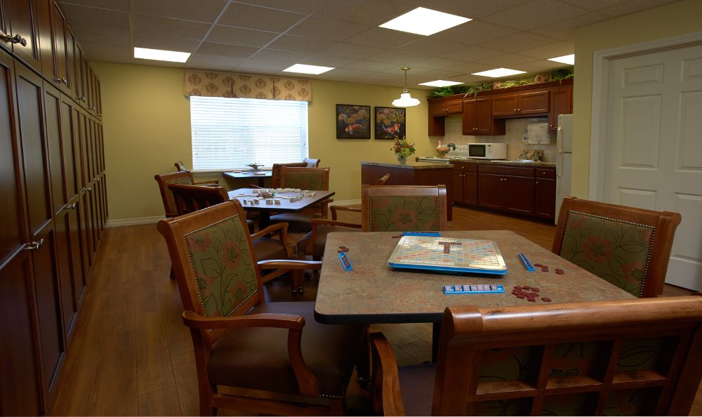 A cozy dining area with wooden tables and chairs, adjacent to a kitchen space.
