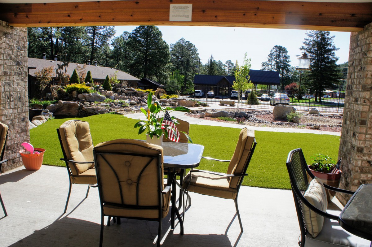 A scenic outdoor patio with comfortable seating overlooking a landscaped garden.