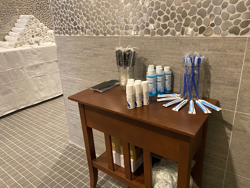 A neatly arranged bathroom amenities station featuring toiletries and toothbrushes on a wooden table.