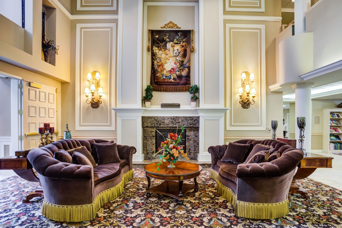 A luxurious living room with elegant sofas and a fireplace, adorned with sophisticated decor.