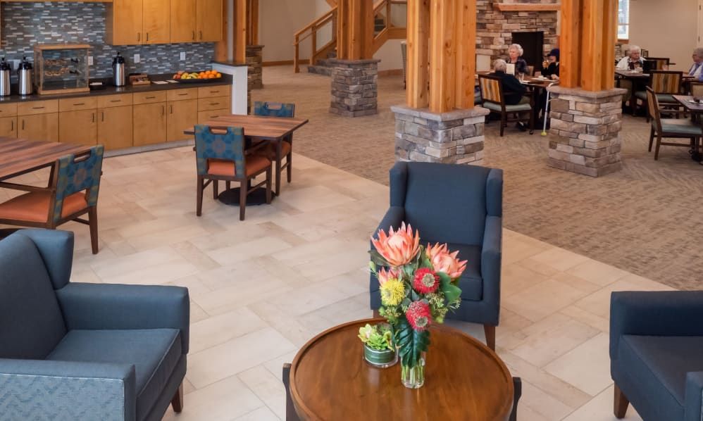 A cozy hotel lobby with elegant furniture and a bouquet of flowers on the table.