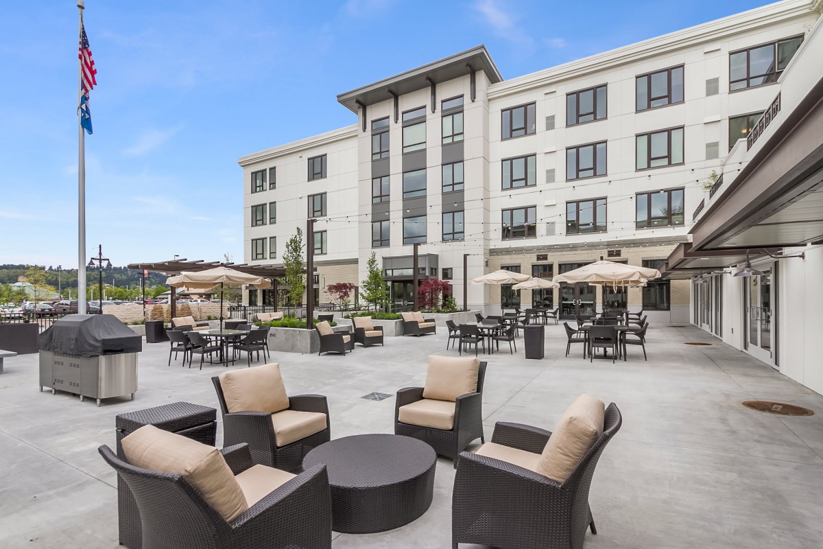 A modern hotel with comfortable outdoor seating on the patio.