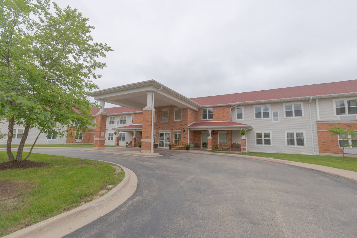 A two-story brick and siding building with a covered entrance and surrounding driveway.