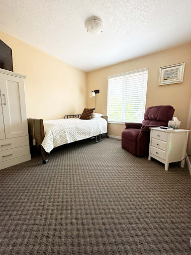 A cozy and well-lit bedroom featuring a single bed, armchair, and tasteful decor.