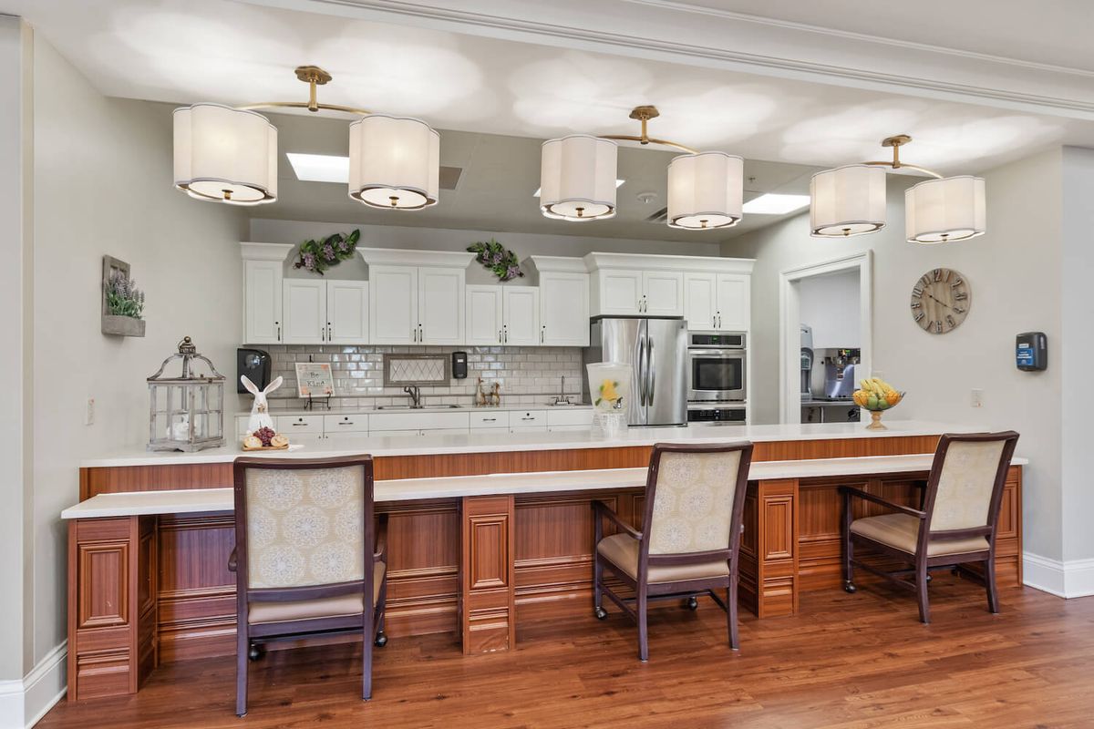A modern kitchen interior with a long counter, elegant lighting, and stylish appliances.