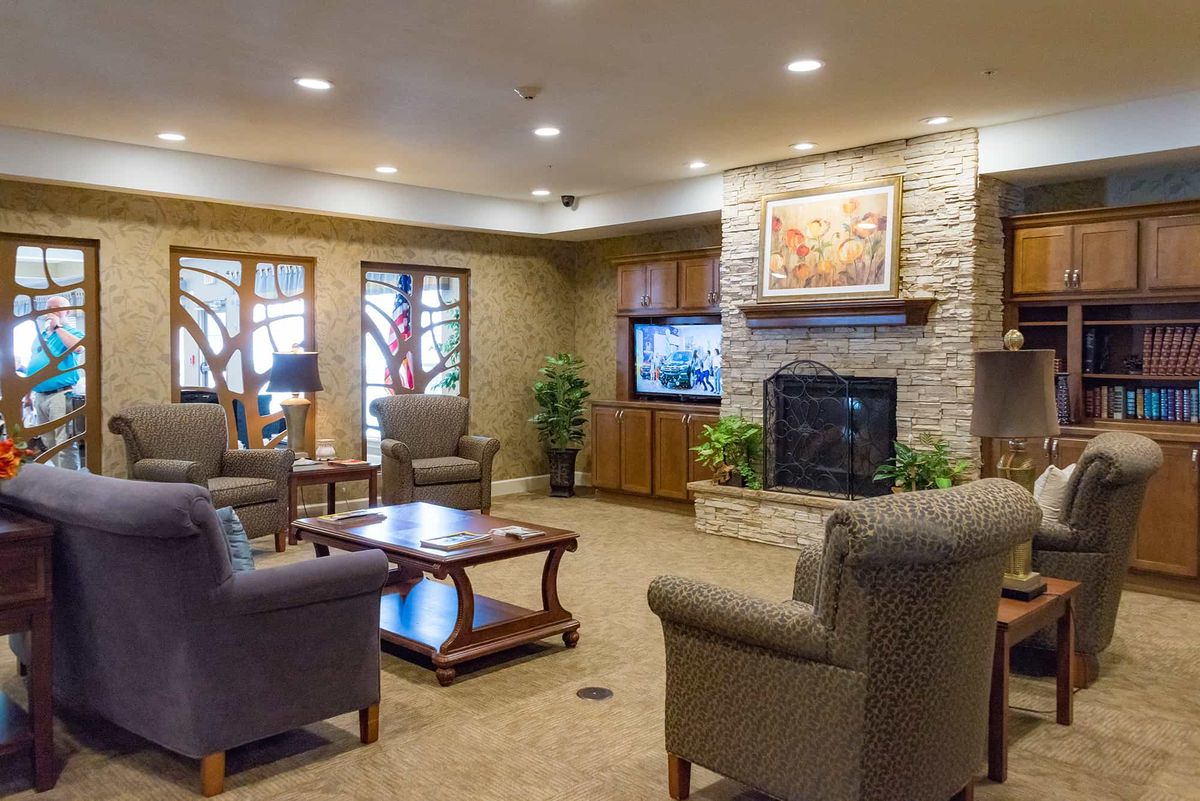 A cozy living room with comfortable seating, a fireplace, and a television.