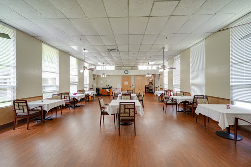 A spacious and well-lit dining room featuring neatly arranged tables and chairs, showcasing a warm and inviting atmosphere.