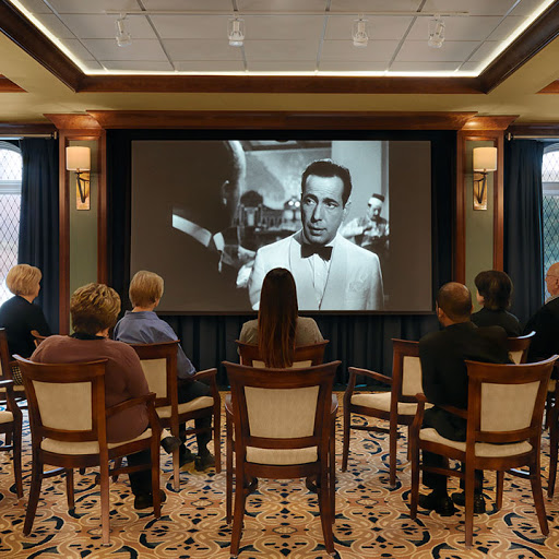 An audience enjoying a black and white film screening in a cozy indoor setting.