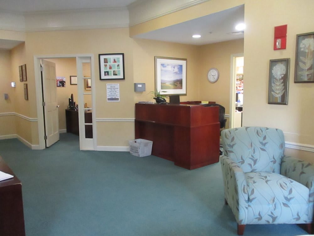 A reception area in an office, featuring a wooden desk and comfortable seating.