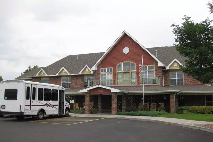 A commercial building with a parked bus in front of its entrance.