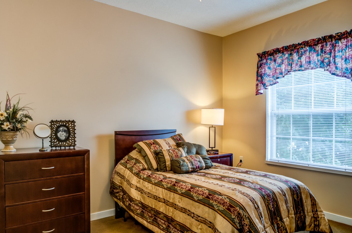 Cozy bedroom with a patterned bedspread and warm lighting.