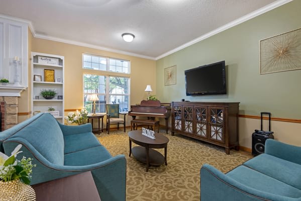 A cozy living room with a TV, sofas, and decorative elements.