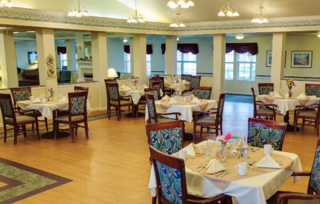 A well-lit dining room with neatly arranged tables and chairs.